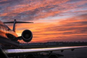 En flygplansvinge mot en röd horisont